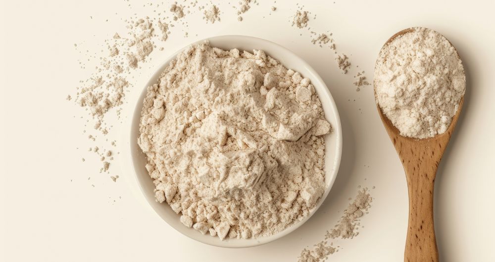 Bowl and wooden spoon filled with protein powder